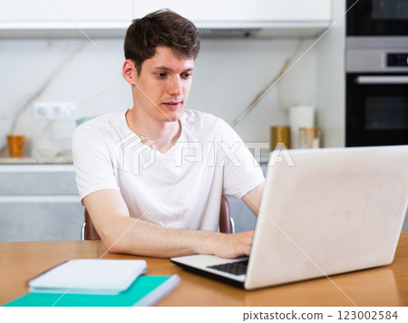 Young guy studying at home with laptop Young guy studying at home with laptop 123002584