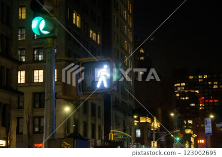 Walk Signal Illuminated at a Busy Intersection in a Vibrant City at Night 123002695