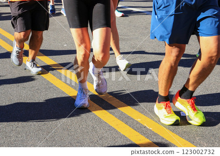 Legs of Runners Running Together During a Marathon 123002732