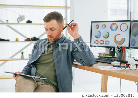 With tablet in hands. Male designer working in the office by using PC 123002815