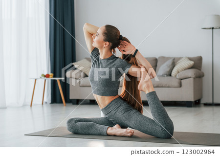 Domestic room. Young woman with slim body type and in yoga clothes is at home 123002964