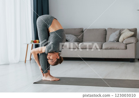 Healthy lifestyle. Young woman with slim body type and in yoga clothes is at home 123003010