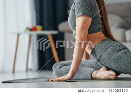 Big stretches. Young woman with slim body type and in yoga clothes is at home 123003115