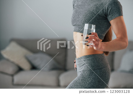Young woman with slim body type and in yoga clothes is at home 123003128