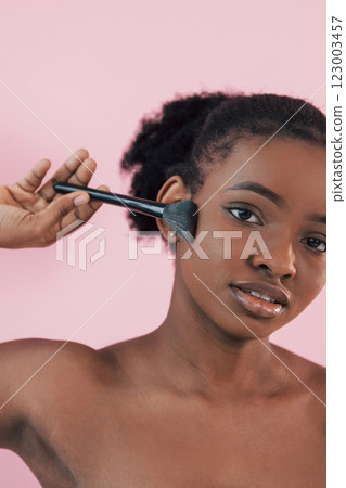With brush. Portrait of young african american woman that is against pink background With brush. Portrait of young african american woman that is against pink background 123003457
