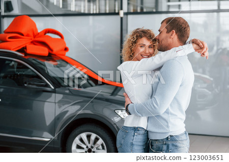 Embracing each other. Husband makes gift for his wife. Modern new car 123003651
