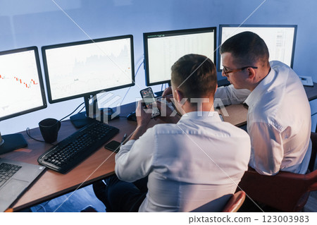 Talking with each other. Two stock traders working in the office with exchange technology 123003983