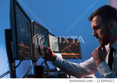 Analyzing data. Stock trader working in the office with exchange technology Analyzing data. Stock trader working in the office with exchange technology 123004021