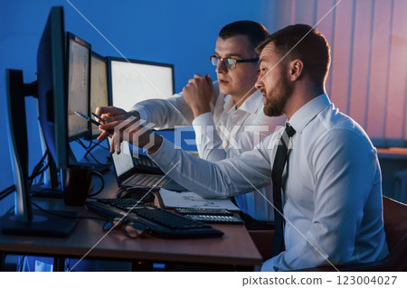 Active conversation. Two stock traders working in the office with exchange technology Active conversation. Two stock traders working in the office with exchange technology 123004027