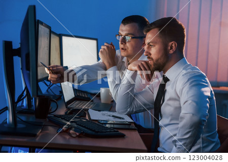 Active conversation. Two stock traders working in the office with exchange technology Active conversation. Two stock traders working in the office with exchange technology 123004028