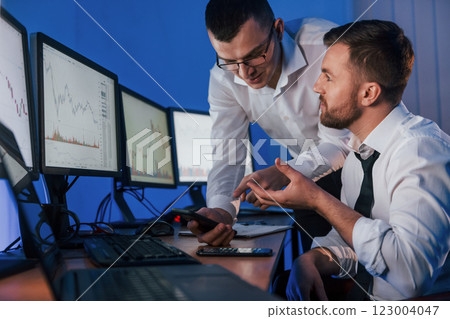 Making profit. Two stock traders working in the office with exchange technology Making profit. Two stock traders working in the office with exchange technology 123004047