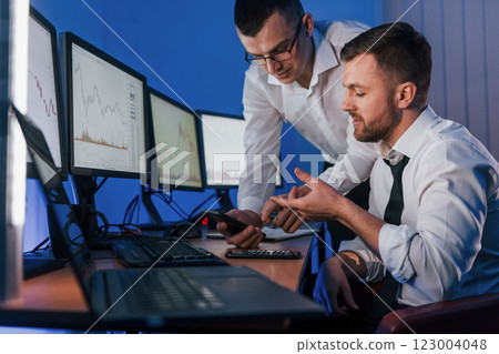 Making profit. Two stock traders working in the office with exchange technology Making profit. Two stock traders working in the office with exchange technology 123004048