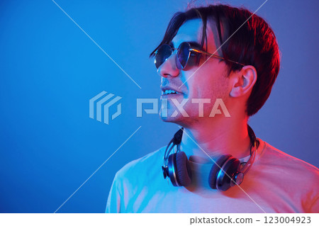 Conception of futuristics. Man standing in the studio with neon light 123004923