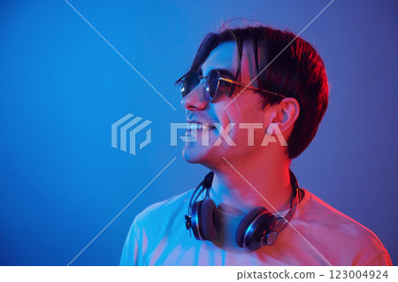 Side view. Man standing in the studio with neon light 123004924