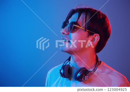 Side view. Man standing in the studio with neon light 123004925