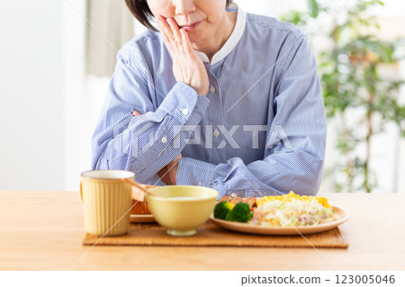 A middle-aged woman worried about her Western-style breakfast 123005046