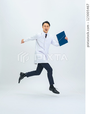 Full-body photo of a middle-aged male doctor/researcher in a white coat jumping Full-body photo of a middle-aged male doctor/researcher in a white coat jumping 123005467