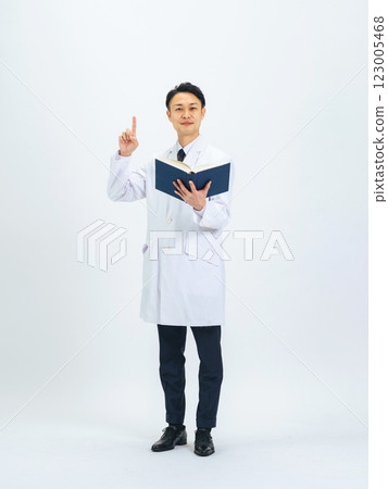 一位身穿白大褂、手持一本書並給予指示的中年男性醫生/研究人員的全身照片 123005468