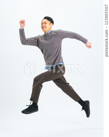 Full body photo of a middle-aged man in casual clothing jumping Full body photo of a middle-aged man in casual clothing jumping 123005507