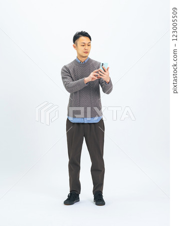 Full-body photo of a middle-aged man using a smartphone Full-body photo of a middle-aged man using a smartphone 123005509