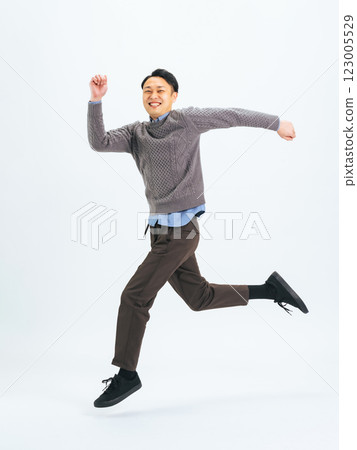 Full body photo of a middle-aged man in casual clothing jumping Full body photo of a middle-aged man in casual clothing jumping 123005529