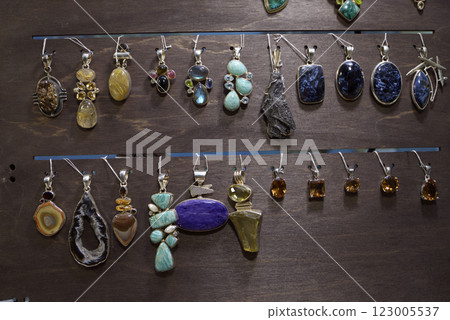 Handmade jewelry made of semi-precious natural stones - jaspers, agates, nephritis in copper frames, placed on the counter 123005537