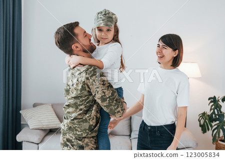 Soldier in uniform is at home with his wife and daughter Soldier in uniform is at home with his wife and daughter 123005834