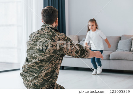 Missed you. Soldier in uniform is at home with his little daughter Missed you. Soldier in uniform is at home with his little daughter 123005839