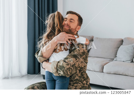 Finally at home. Soldier in uniform is with his little daughter 123005847