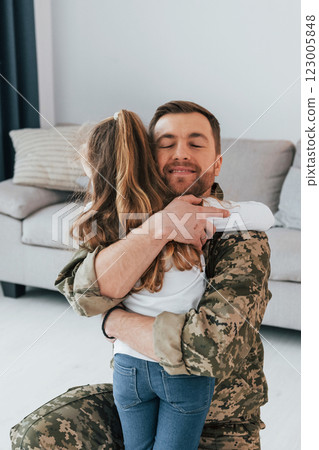 Finally at home. Soldier in uniform is with his little daughter 123005848