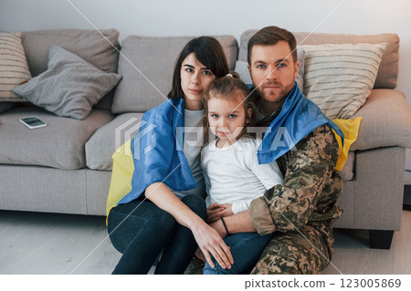 Supoort Ukraine conception. Soldier in uniform is at home with his wife and daughter 123005869