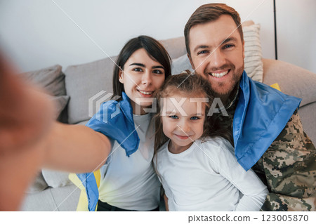 Supoort Ukraine conception. Soldier in uniform is at home with his wife and daughter 123005870