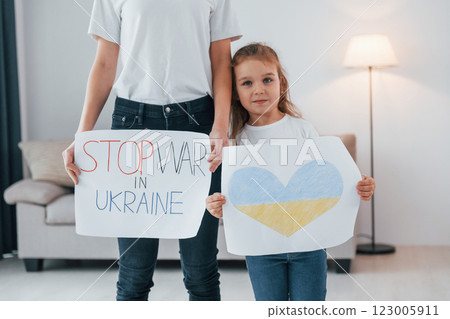 Mother with her little daughter standing with banners with text stop war in Ukrane Mother with her little daughter standing with banners with text stop war in Ukrane 123005911