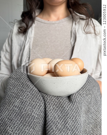 Woman keeping fresh farm chicken eggs in bowl Woman keeping fresh farm chicken eggs in bowl 123005912