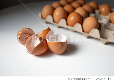 Eggshells and eggs in a paper tray on white table 123005917