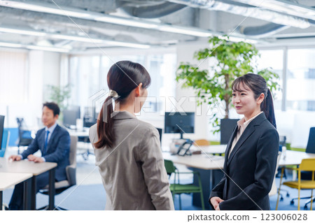 A fresh-faced woman being shown around the office by a senior employee 123006028