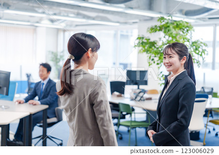A fresh-faced woman being shown around the office by a senior employee 123006029