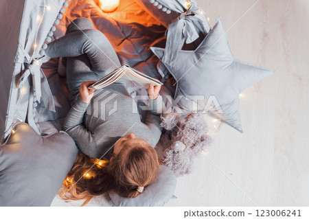 Interesting book. Cute little girl playing in the tent that is in the domestic room 123006241
