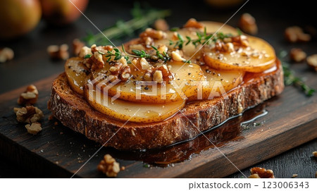 Delicious open-faced toasted bread topped with pears, walnuts, and honey served on a wooden board 123006343