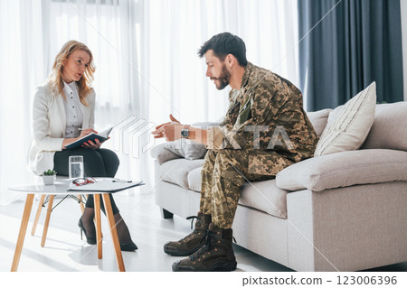 Side view. Soldier have therapy session with psychologist indoors 123006396