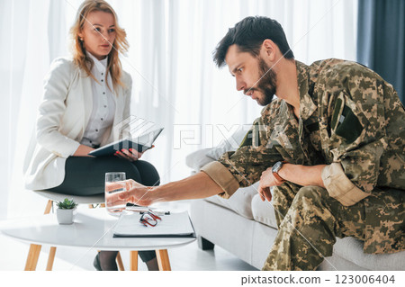 Process of recovery. Soldier have therapy session with psychologist indoors 123006404