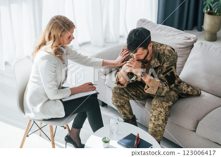 Post traumatic stress disorder. Soldier have therapy session with psychologist indoors 123006417