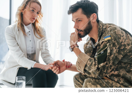 Post traumatic stress disorder. Soldier have therapy session with psychologist indoors 123006421