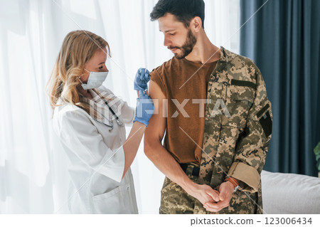 Soldier get vaccinated by female doctor indoors Soldier get vaccinated by female doctor indoors 123006434