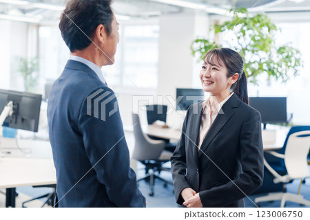 微笑的年輕女商人與老闆交談 微笑的年輕女商人與老闆交談 123006750