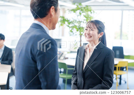 Smiling young businesswoman talking to her boss 123006757