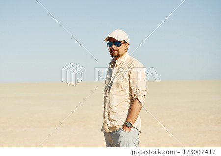 Standing and posing. Male tourist in casual clothes is in the deserts of Africa, Namibia Standing and posing. Male tourist in casual clothes is in the deserts of Africa, Namibia 123007412