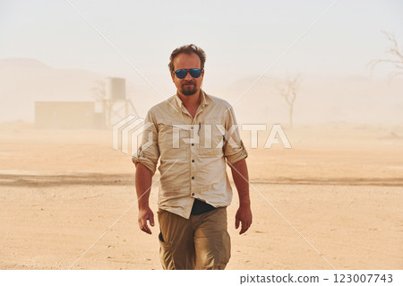 In the dead city. Male tourist in casual clothes is in the deserts of Africa, Namibia 123007743