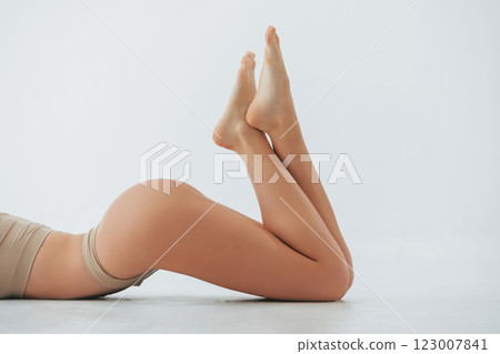 Close up side view. Woman in underwear with slim body type is posing in the studio 123007841