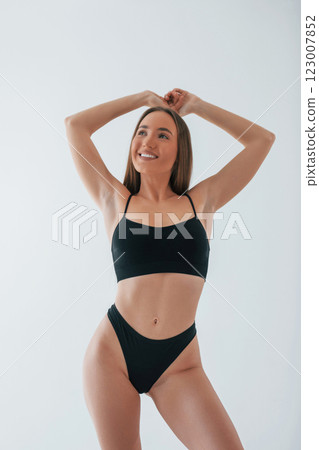 Beautiful female with brown hair. Woman in underwear with slim body type is posing in the studio 123007852